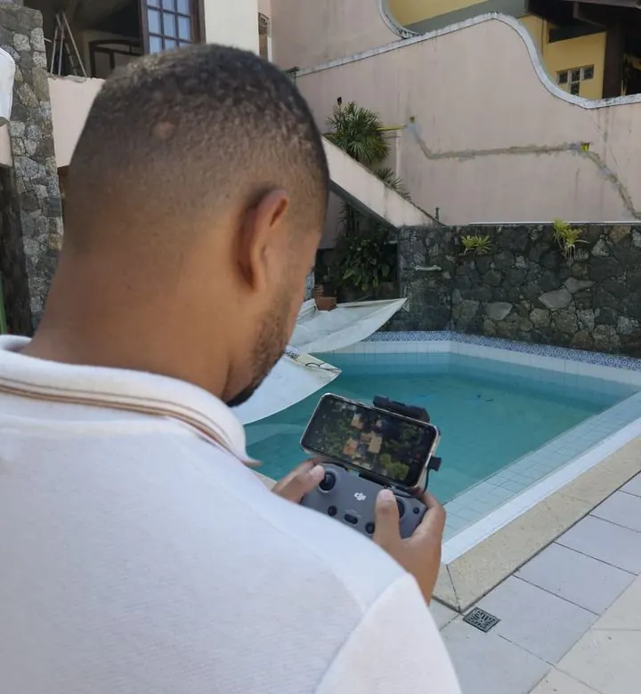 Rhuann pilotando um drone durante a vistoria de uma residência com fissuras na fachada